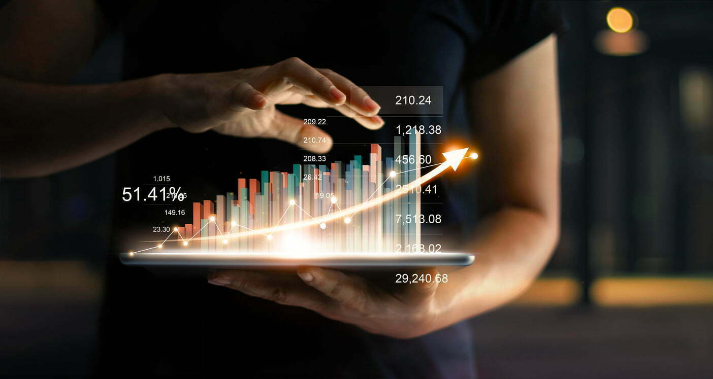 Businessman holding tablet and showing a growing virtual hologram of statistics, graph and chart with arrow up on dark background. Stock market. Business growth, planing and strategy concept. master data management zeenea